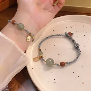 Handgefertigtes gewebtes Armband mit grünen Natursteinperlen und goldenem Fu-Anhänger