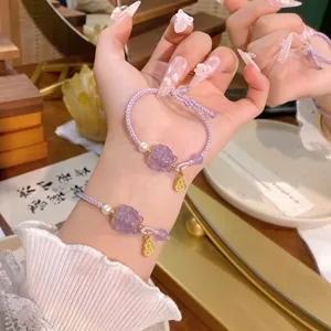 Handgeflochtenes lila Seilarmband mit geschnitztem Naturstein und elegantem Perlenakzent