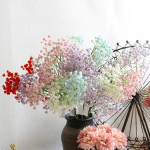 Detailed close-up of colorful artificial baby's breath flowers in a rustic ceramic vase