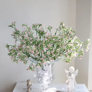 Elegantes flores de paniculata artificial rosa en un jarrón de cristal para el hogar
