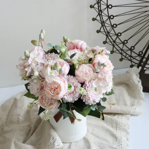 Primer plano detallado de un ramo de peonías y hortensias rosas en un jarrón blanco