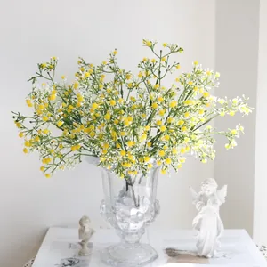 Vista detallada de flores de paniculata artificiales amarillas y blancas en un jarrón
