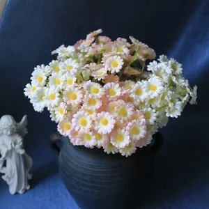 Detailed view of pink and white artificial daisies in a vintage dark ceramic vase