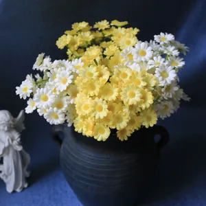 Close-up of yellow and white artificial daisies in a vintage ceramic vase