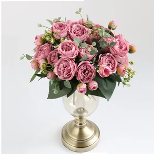 Elegant vintage roze kunstmatige pioenrozen boeket in een klassieke glazen en koperen vaas