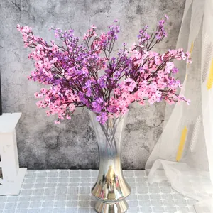 Flores de gipsófila artificiales rosas y moradas en un elegante jarrón para decoración del hogar.