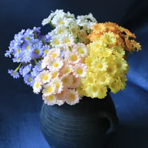 Detailed close-up of vibrant multicolored artificial daisies arranged in a dark rustic vase.