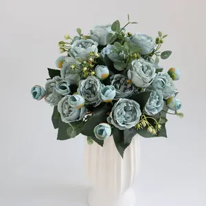 Elegante lichtblauwe kunstmatige pioenrozen boeket in witte geribbelde vaas voor huis.