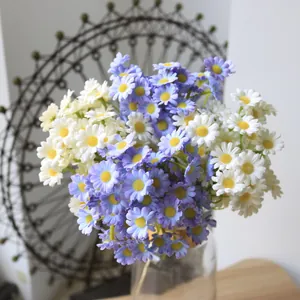 Close-up detail of artificial white and purple daisies arranged in a clear glass vase