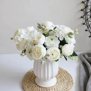 Detalle de ramo artificial de peonías y hortensias blancas en un jarrón de estilo nórdico