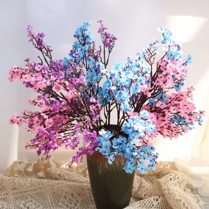 Vista detallada de flores artificiales de paniculata en seda azul y violeta en un jarrón