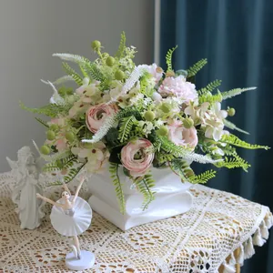 Elegante arreglo de ranúnculos y hortensias artificiales en un jarrón de cerámica blanca