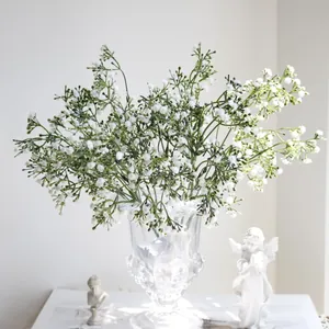 Elegante ramo de paniculata artificial blanca en un jarrón de cristal para decoración