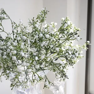 Vista detallada de flores de paniculata artificial en jarrón de cristal para bodas