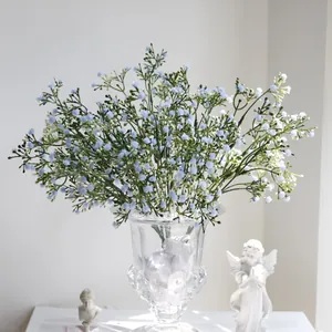Detalle de ramo de paniculata artificial azul en un jarrón de cristal decorativo