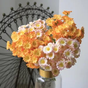 Detailed macro view of vibrant artificial orange and pink daisies in a clear vase