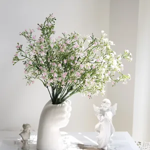 Primer plano de flores de paniculata rosa artificiales en un moderno jarrón de cerámica