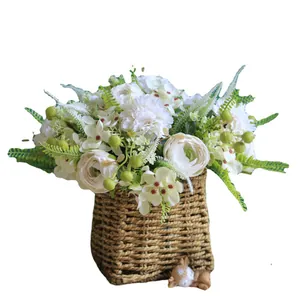 Arreglo de flores artificiales de claveles y hortensias blancas en cesta tejida