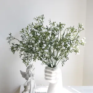 Vista detallada de un ramo de paniculata blanca artificial en un jarrón creativo de puño