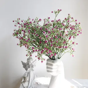Flores de gypsophila artificiales rosas y blancas en un original jarrón de puño
