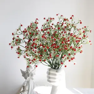 Primer plano de flores de paniculata artificiales en un jarrón blanco de puño
