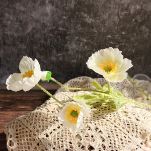 Primer plano de amapolas blancas artificiales de seda con tallos suaves y centro amarillo