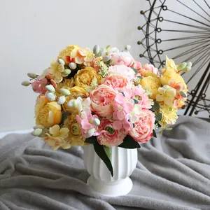 Elegante ramo de peonías y hortensias artificiales con bayas en un jarrón de cerámica.