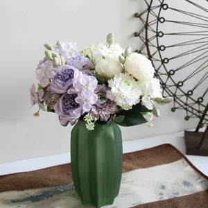 Primer plano de un elegante ramo de peonías y hortensias en un jarrón decorativo verde