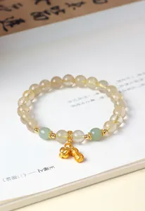 Detailaufnahme eines Goldquarz-Armbands mit Jade-Perlen und Erdnuss-Anhänger