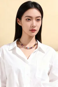 Primer plano de un collar de cuentas de cristal natural multicolor en una modelo