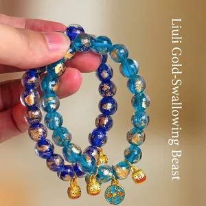 Elegante blaue Glasperlenarmbänder mit Goldfolie und goldenen Fabelwesen-Anhängern