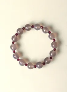 Detalle de cerca de pulsera de cuentas de ágata gris y granate rojo natural