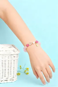 Detailansicht eines rosa Kristallperlenarmbands am Handgelenk einer Frau