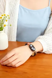 Gros plan d'un bracelet vintage en bois de santal et pierre Shoushan avec détails de fleurs