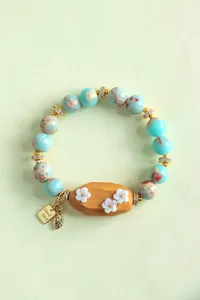 Gros plan détaillé d'un bracelet en pierre de Shoushan avec bois de santal et fleurs