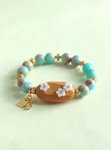 Détail exquis du bracelet en pierre naturelle avec perle fleur en bois de santal
