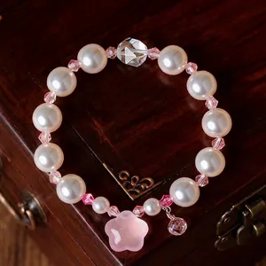 Elegante bracciale di perle bianche con accenti di cristallo rosa e ciondolo a stella