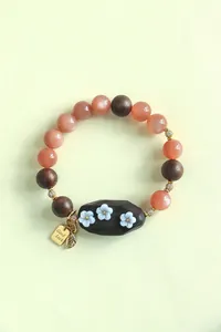 Vue détaillée du bracelet en perles de pierre de Shoushan et santal avec fleurs blanches