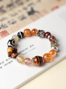 Detailed view of Tibetan-style crystal bead bracelet with silver charms on a book