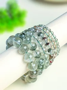 Close-up detail of layered natural green phantom quartz crystal beaded bracelets