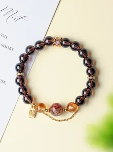 Detailed view of obsidian and super seven crystal bracelet with lucky charm.