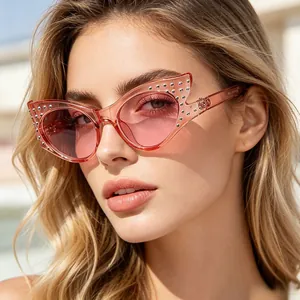 Detalle de gafas de sol tipo gato con pedrería en una montura rosa transparente moderna
