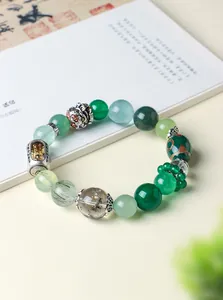 Close-up of Tibetan style crystal bracelet with gold rutilated quartz and green agate beads