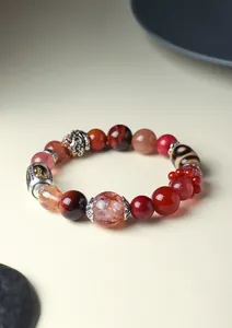 Detailed macro view of a Tibetan style crystal bracelet featuring a Dzi bead and Vajra charm