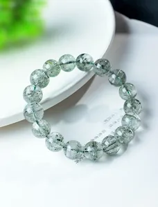 Macro view of natural green phantom quartz beaded bracelet showing internal inclusions