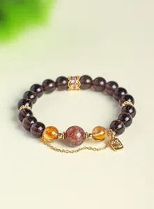 Detailed macro view of natural obsidian and citrine crystal beaded bracelet with charm
