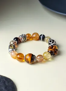 Close-up of Tibetan style crystal bracelet with rutilated quartz and tiger eye beads.