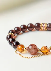 Exquisite detail showing natural obsidian and citrine beads on a luxury gold chain bracelet