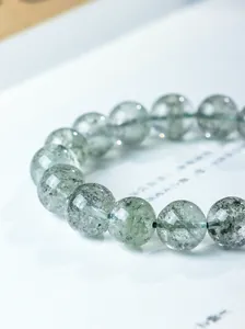 Macro view of natural Green Phantom Quartz beads showing thousand-layer gauze details.