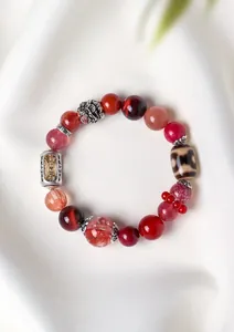 Detailed view of Tibetan style crystal bracelet with red beads and engraved silver barrel.